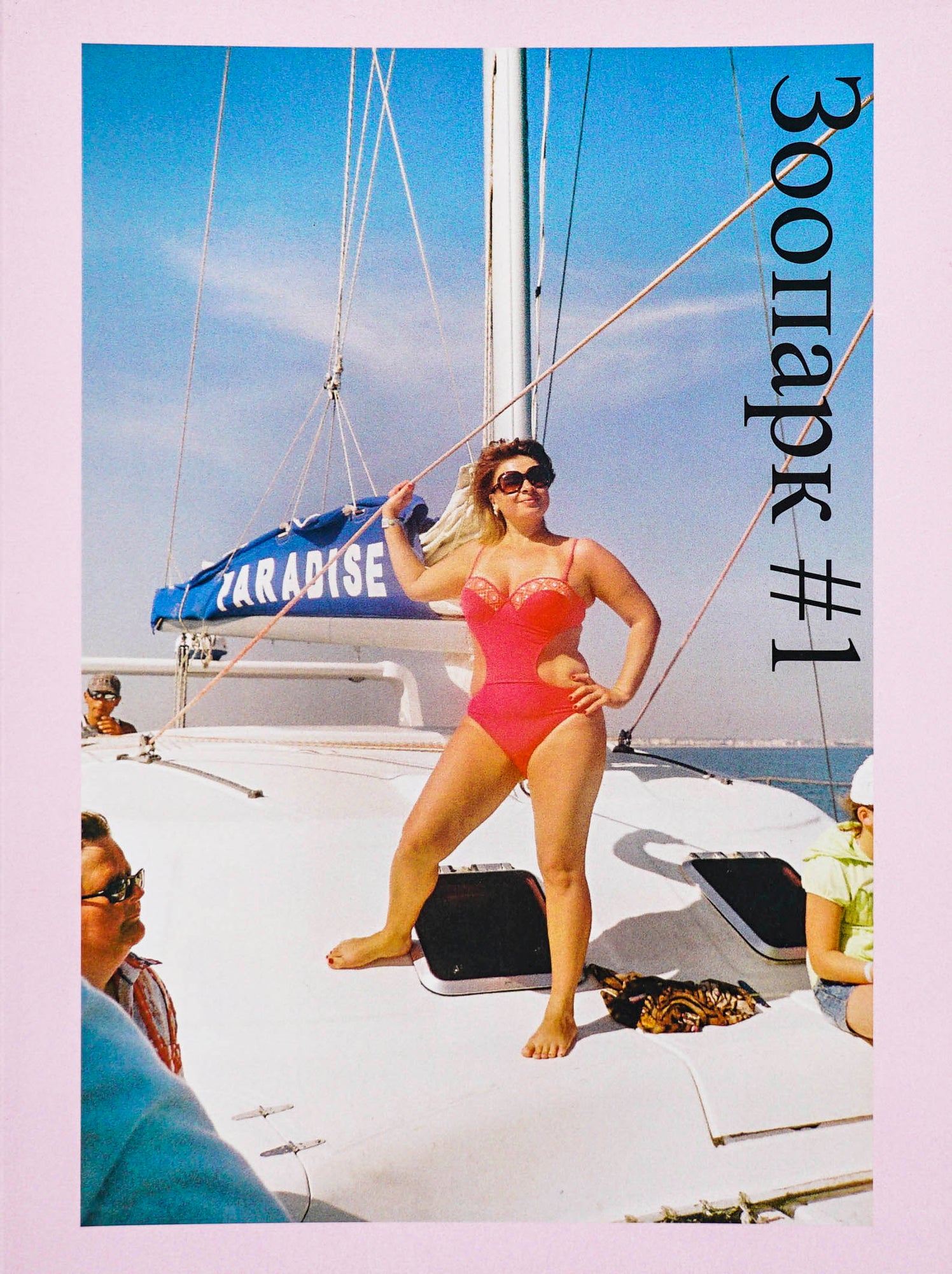 Phtotograph of a woman posing in a red bathing suit on a yacht facing the camera with Russian letters #1 in black serif type
