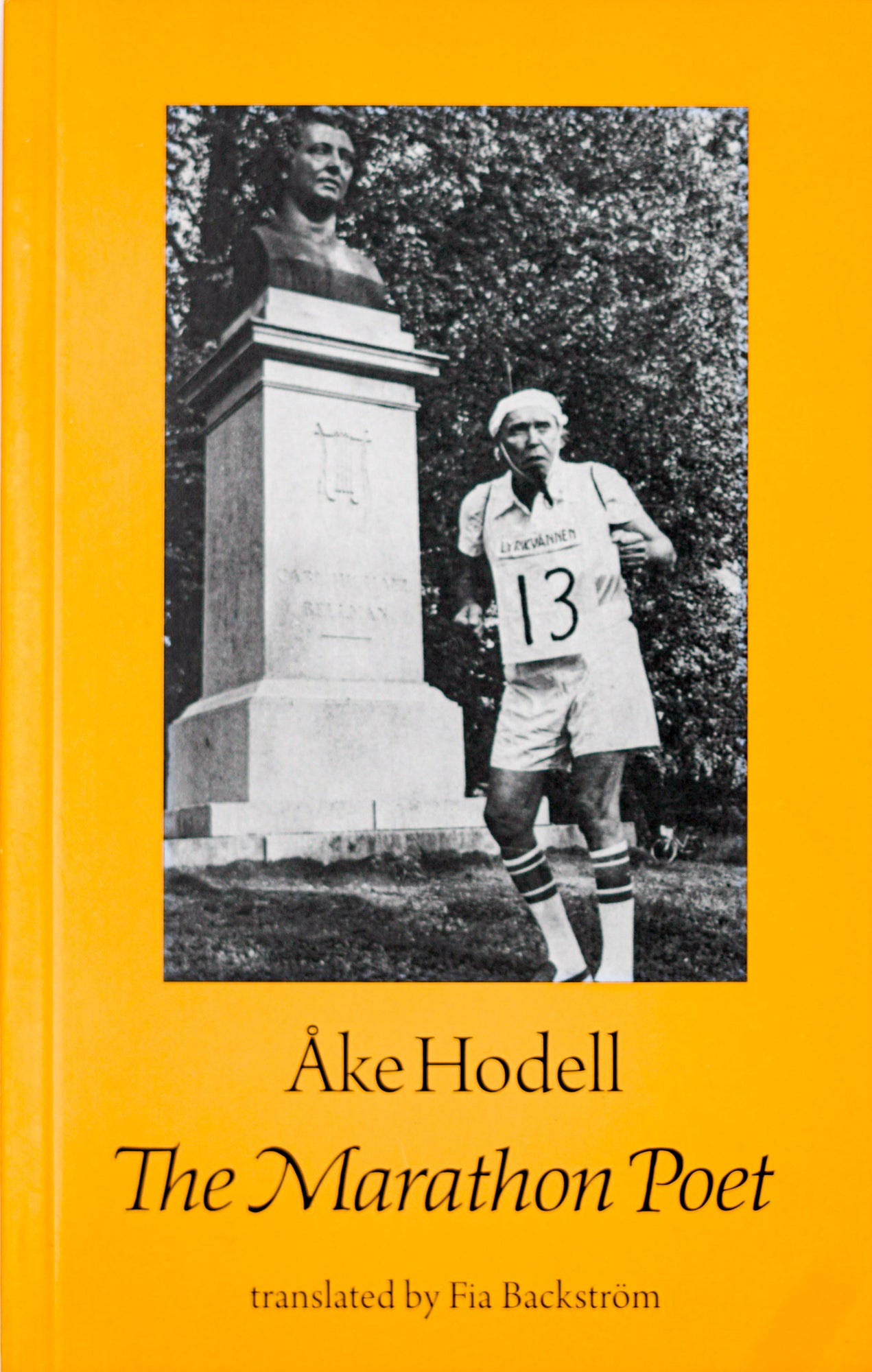 Book Cover in light orange with a black and white photography central on the page. The picture shows an elderly person in front of a tombstone in sports clothing and a sign saying the number 13 on his chest. Below that it says the author Ake Hodell in black serif roman writing and below that the title The Marathon Poet in black serif italic.